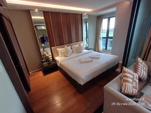 una camera d'albergo con un letto e un divano di Mida Grand Resort Phuket a Ban Lum Fuang