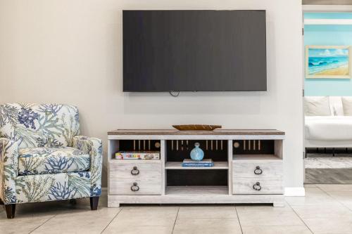 a living room with a tv and a chair at Nocatee Retreat with Fenced Yard & Lanai in Sampson