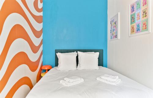 - une chambre avec un lit et 2 serviettes blanches dans l'établissement Magnifique appartement coloré #GareMontparnasse-II, à Paris