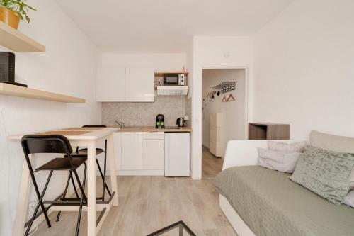 une cuisine et un salon avec un canapé et une table dans l'établissement Le Studio du Palais - Centre Nancy Gare Congrès - 2 Pers, à Nancy