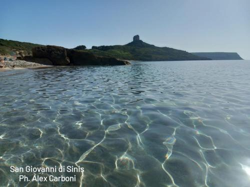 a body of water with a hill in the background at Casa Vacanze di Alex in Càbras