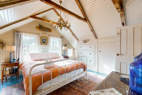 a bedroom with a bed and a ceiling with beams at The Groggy Anchor in Provincetown