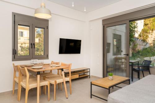 a dining room with a table and chairs and a tv at Dreta Suites in Chania Town