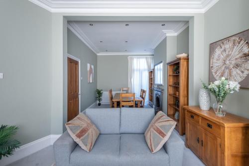 a living room with a blue couch and a table at Lrg Stunning 5BD CrouchEnd House in London