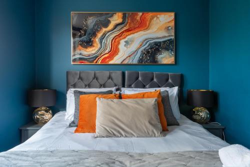 a blue bedroom with a bed with orange pillows at Lrg Stunning 5BD CrouchEnd House in London