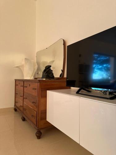 a television on a dresser with a mirror on it at oasi di pace fasano BIS in Fasano