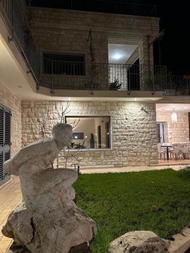 a statue in front of a stone house at night at oasi di pace fasano BIS in Fasano