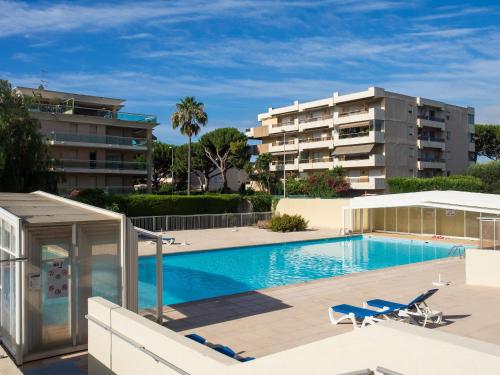 Heliotel Marine Studio avec balcon au 4eme étage à 200m de la mer في سان لوران دو فار: مسبح مع كرسيين صالة ومبنى