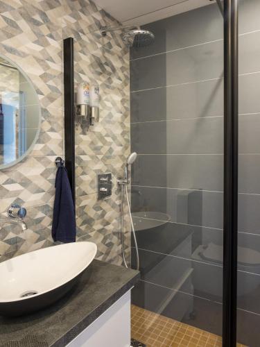 une salle de bain avec un lavabo et une douche dans l'établissement Heliotel Marine Studio avec balcon au 4eme étage à 200m de la mer, à Saint-Laurent-du-Var