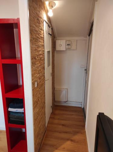 une petite chambre avec une étagère rouge et un couloir dans l'établissement Studio idéal visite de Paris, à Ivry-sur-Seine