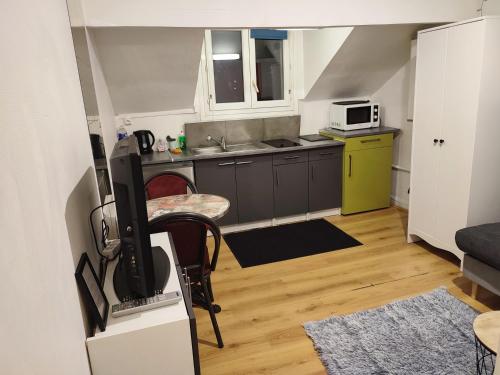 Il comprend une petite cuisine avec une table et une télévision. dans l'établissement Studio idéal visite de Paris, à Ivry-sur-Seine