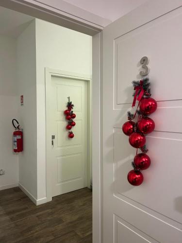 a hallway with red ornaments on the door at La Maison Foggia in Foggia