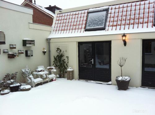 a yard covered in snow next to a house at Bed & Breakfast Diemerbrug in Amsterdam