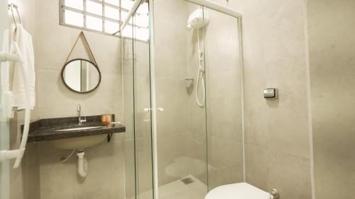 a bathroom with a shower and a toilet and a sink at Jahu Center Plaza Flats in Jaú