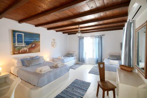 a bedroom with a bed and a chair in it at Blue Bay Heliolithos in Parikia