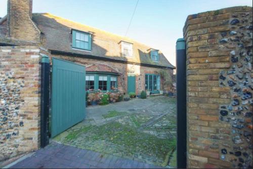 a brick house with a green gate in front of it at Coastal Cottage Escape in Ramsgate