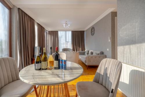 a living room with a table with wine bottles on it at 4Season Villa in Tbilisi City