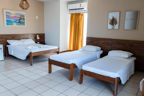 a hospital room with two beds and a window at INTER HOTEL JACARAÍPE in Serra