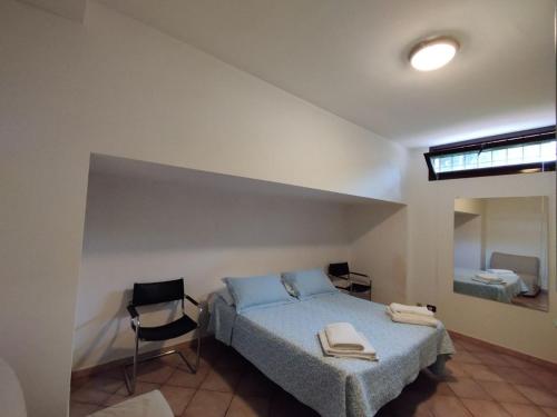 a bedroom with a bed and two chairs in it at Masaya house in Ronciglione