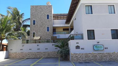 a white building with a clock on the side of it at Flecheiras Residence in Flecheiras