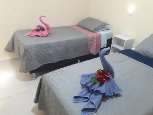 two beds with swans on them in a room at Flecheiras Residence in Flecheiras