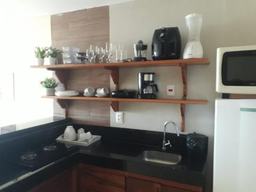 a kitchen with a sink and a microwave at Flecheiras Residence in Flecheiras