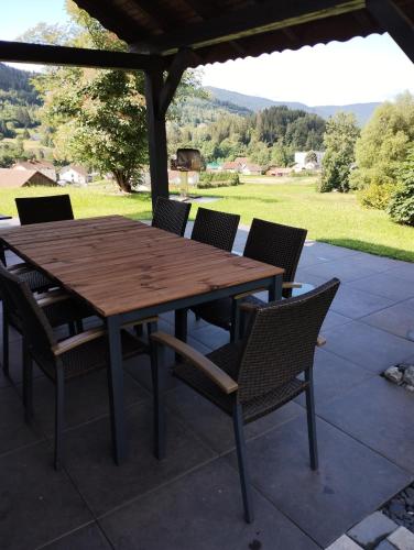 une table et des chaises en bois sur une terrasse dans l'établissement Superbe chalet Hautes Vosges, à Cornimont