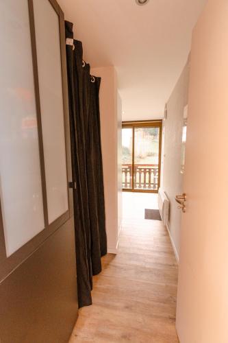 a hallway with a door open to a room at L'Horizon des Randonneurs - Duplex avec Balcon in Les Hôpitaux-Neufs