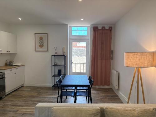 un salon avec une table et une cuisine dans l'établissement Appartement cosy avec balcon, à Roanne