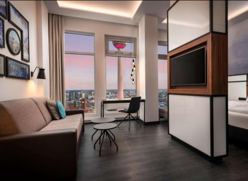 un soggiorno con un divano e una TV di Park Inn by Radisson Berlin Alexanderplatz a Berlino