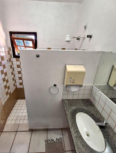 a bathroom with a sink and a dispenser on the wall at Cantinho dos Aquários in Arraial d'Ajuda