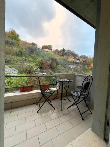 a balcony with two chairs and a table and a window at Casa Celeste in Nocera Umbra