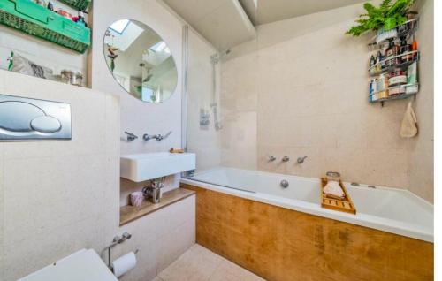 a bathroom with a tub and a sink and a mirror at Charming Dulwich Cottage in West Dulwich