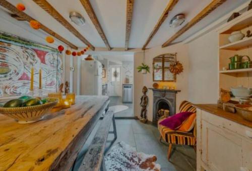 a living room with a table and a fireplace at Charming Dulwich Cottage in West Dulwich