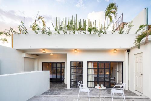 a white house with plants on the roof at Casa Lumos - Minimalist Comfort Suites in Centro Historico in Oaxaca City