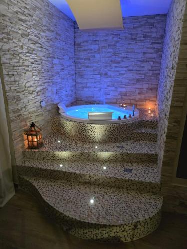 a bathroom with a jacuzzi tub in a brick wall at Elite Apartment SPA in Catania