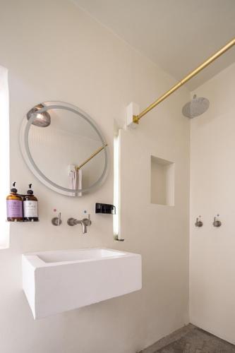 a white bathroom with a sink and a mirror at Casa Lumos - Minimalist Comfort Suites in Centro Historico in Oaxaca City