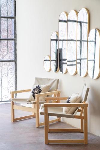a living room with two chairs and a chandelier at Casa Lumos - Minimalist Comfort Suites in Centro Historico in Oaxaca City