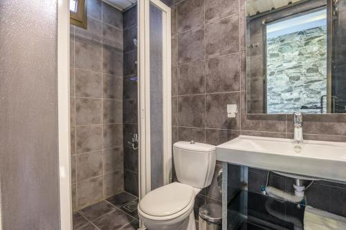 a bathroom with a toilet and a sink and a mirror at Villagio Resort in Zaarour in Zaarour