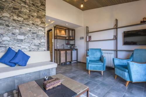 a living room with a couch and two blue chairs at Villagio Resort in Zaarour in Zaarour
