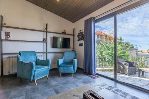 two blue chairs in a living room with a sliding glass door at Villagio Resort in Zaarour in Zaarour