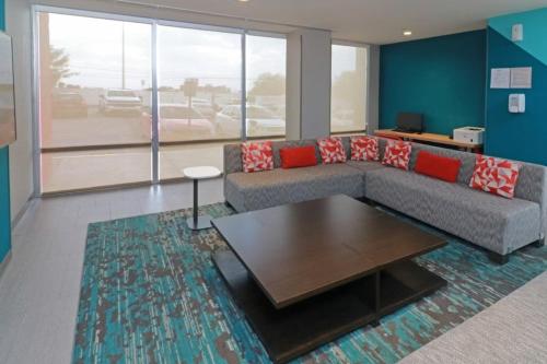 a living room with a couch and a coffee table at Avid Hotel Querétaro Centro Sur by IHG in Querétaro