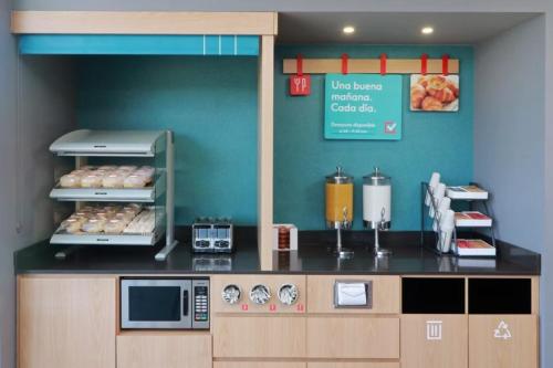 a fast food kitchen with a counter with food at Avid Hotel Querétaro Centro Sur by IHG in Querétaro