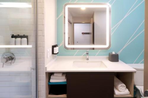 a bathroom with a sink and a mirror at Avid Hotel Querétaro Centro Sur by IHG in Querétaro