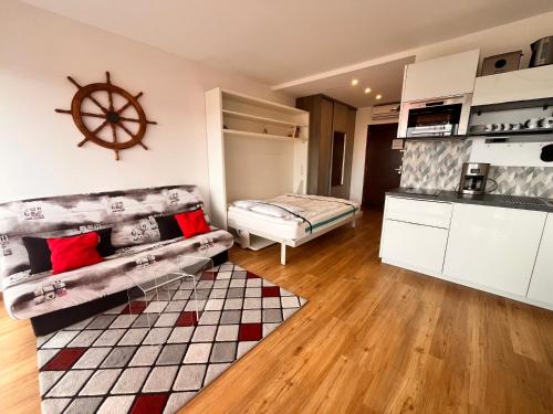 Heliotel Marine Studio avec balcon au 4eme étage à 200m de la mer في سان لوران دو فار: غرفة معيشة مع أريكة ومطبخ