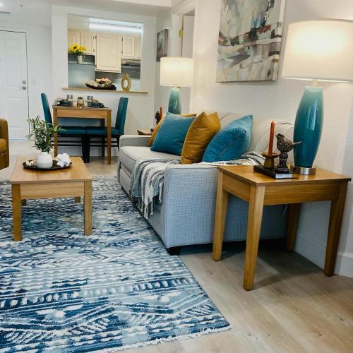 a living room with a blue couch and tables at B&J Hotels in Roswell