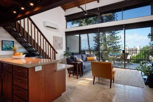 an open kitchen and living room with large glass windows at Stylish Maui Loft Split AC Ocean Views Lanai in Kihei