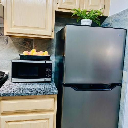 a kitchen with a stainless steel refrigerator and a microwave at B&J Hotels in Roswell