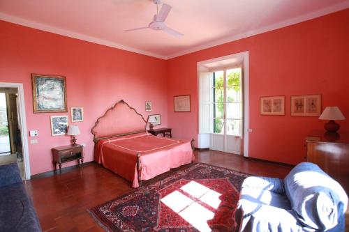 Un dormitorio con paredes rojas y una cama y un sofá. en Villa Acacia, en Florencia