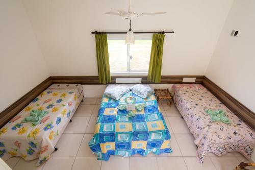 a room with two beds and a window at Hotel Fazenda Pé da Serra in Bom Sucesso